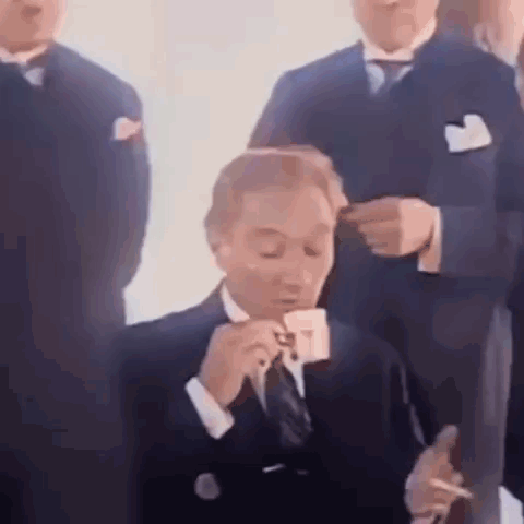 Man in Suit Smoking Cigarette Drinking Cup