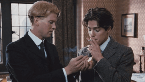 Man in Suit Smoking Cigarette Next to Another Man