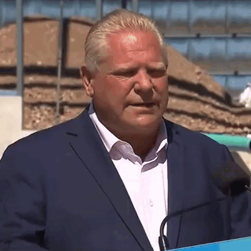 Man in Suit Speaking into Microphone