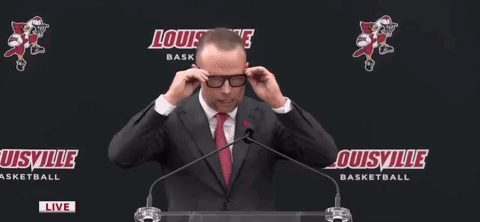 Man in Suit Speaking Into Microphone