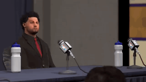 Man in Suit Speaking Into Microphone