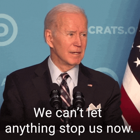 Man in Suit Speaking Into Microphone Saying We Can't Let Anything Stop Us Now