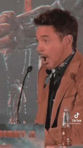 Man in Suit Standing at Microphone With Mouth Open