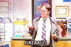 Man in Suit Standing Before Fireball Sign
