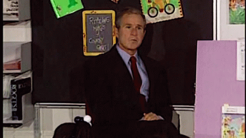 Man in Suit Standing Before Returns Blackboard