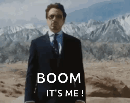 Man in Suit Standing in Desert With Mountains