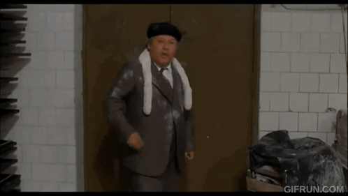 Man In Suit Standing In Front Of Door GIF