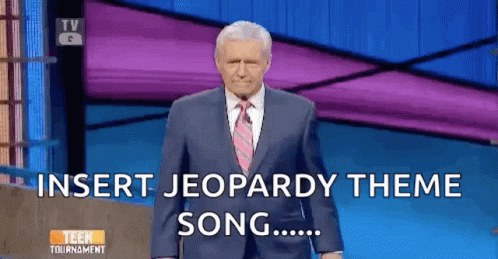 Man In Suit Standing In Front Of Jeopardy Screen GIF