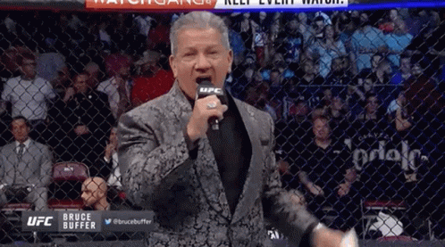 Man In Suit Standing In Front Of Microphone GIF