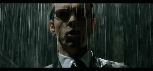 Man in Suit Standing in Rain With Sunglasses
