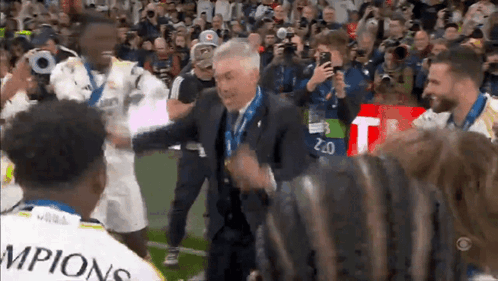 Man in Suit Surrounded by Soccer Champions
