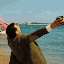 Man in Suit Taking Ocean Photo