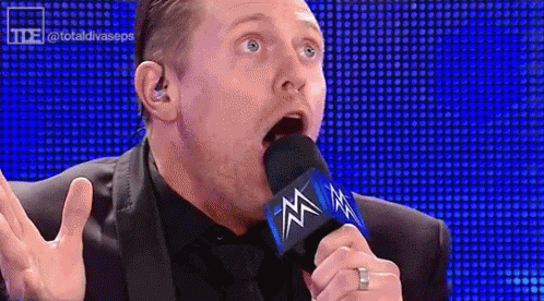 Man In Suit Talking Into Microphone GIF