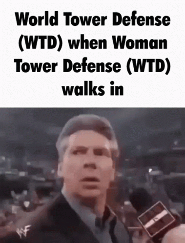 Man in Suit Talking Into Microphone Wearing World Tower Defense T-Shirt