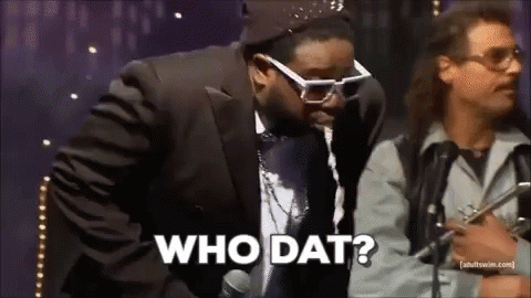 Man in Suit Talking Into Microphone While Another Says Who Dat