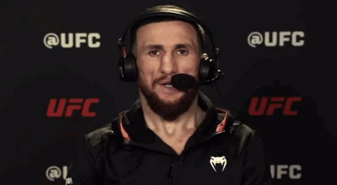 Man In Suit Talking Into Microphone With UFC Logo GIF