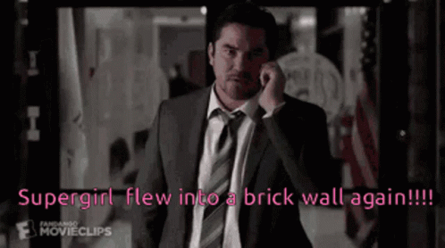 Man in Suit Talking on Cell Phone Says Supergirl Flew Into Brick Wall Again