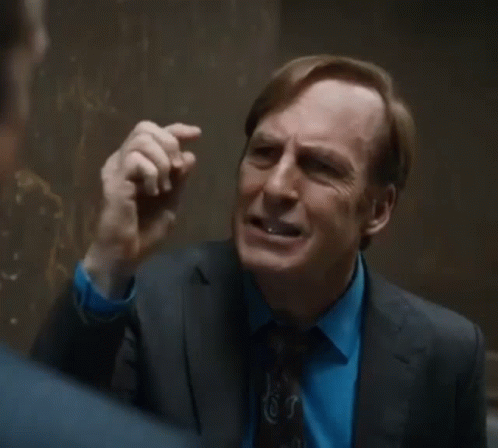 Man in Suit Talking to Another in Hallway
