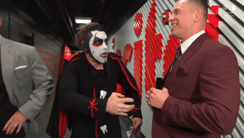 Man in Suit Talking to Costumed Man