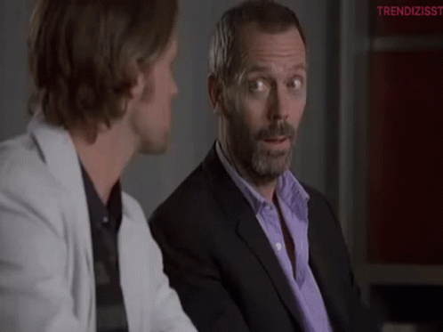 Man in Suit Talking to Man in White Jacket