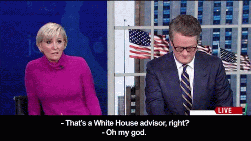 Man In Suit Talking To Woman In Pink GIF