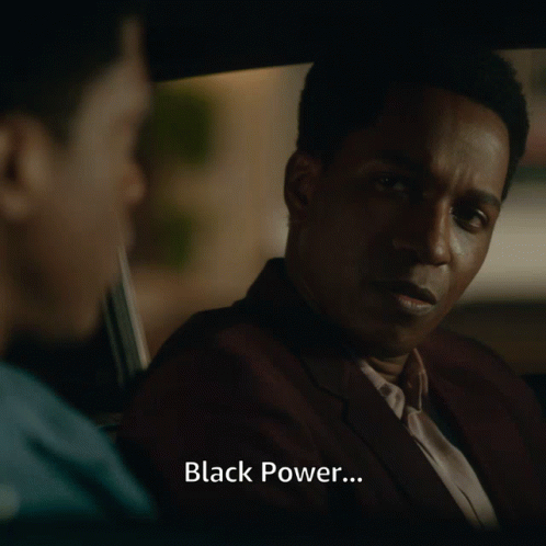 Man in Suit Talks to Another Man in Car With Black Power