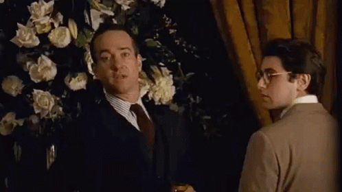 Man In Suit Thumbs Up Beside Man In Brown Sweater GIF