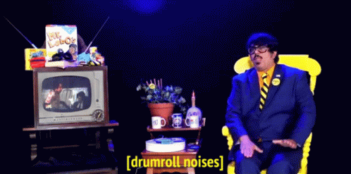 Man In Suit Tie Watching TV Drumroll Noises GIF
