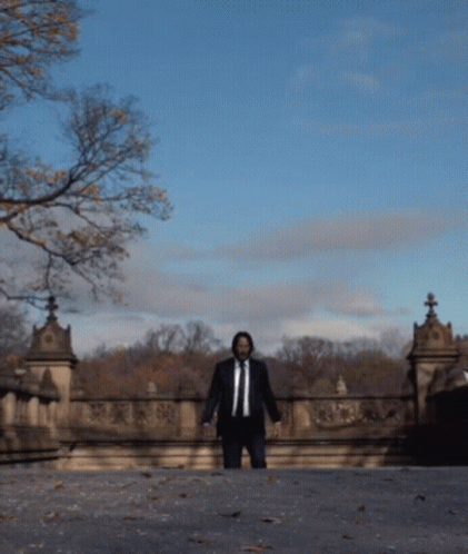 Man in Suit Walking Bridge