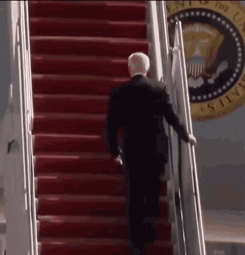 Man in Suit Walking Down Red Stairs