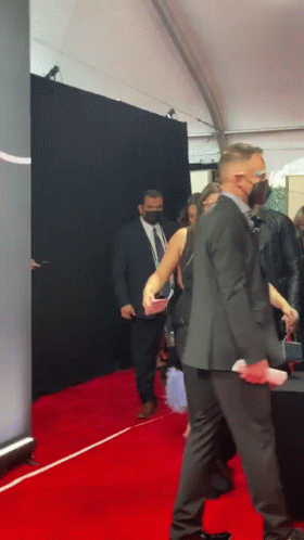 Man in Suit Walking Red Carpet With Woman