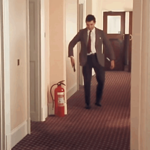 Man In Suit Walking With Fire Extinguisher GIF