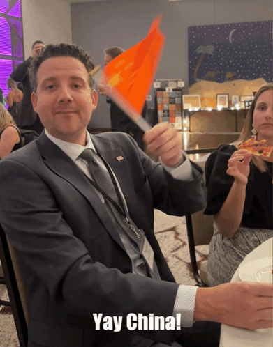 Man in Suit Waving Orange Flag Yay China
