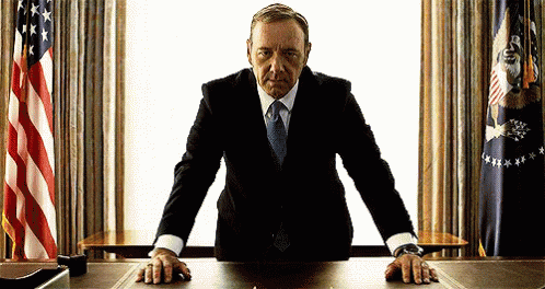 Man in Suit With Hands on Desk