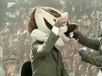 Man in Suit With Mascot on Head Shaking Hands