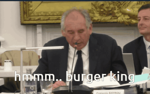 Man in Suit with Microphone Saying Hmm
