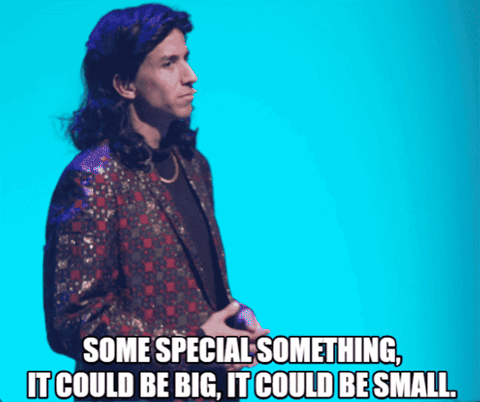 Man in Suit With Microphone Saying It Could Be Big and Small