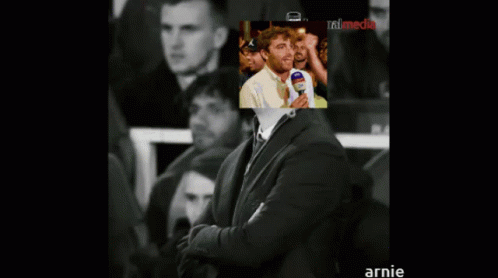 Man In Suit With Picture Behind Saying Annie GIF