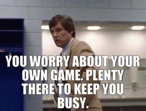 Man in Suit with Sign You Worry About Your Own Game