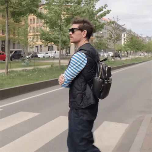 Man In Sunglasses And Black Backpack Crossing Street GIF