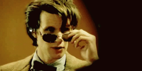 Man in Sunglasses and Bow Tie Looking in Mirror