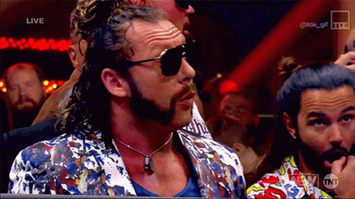 Man in Sunglasses and Colorful Jacket Watching Wrestling