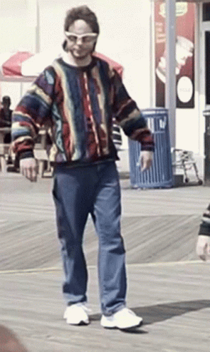 Man in Sunglasses and Colorful Sweater Walking