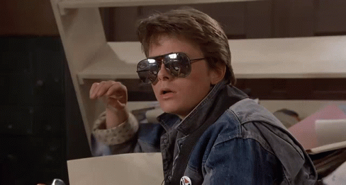 Man in Sunglasses and Denim Jacket Holding Paper