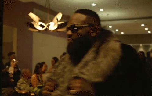 Man In Sunglasses And Fur Coat Before Crowd GIF