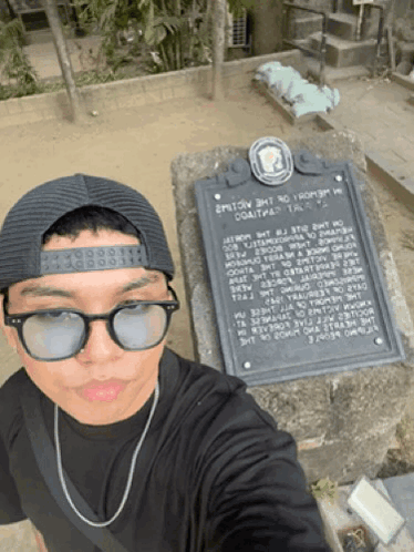 Man in Sunglasses and Hat at Historical Monument