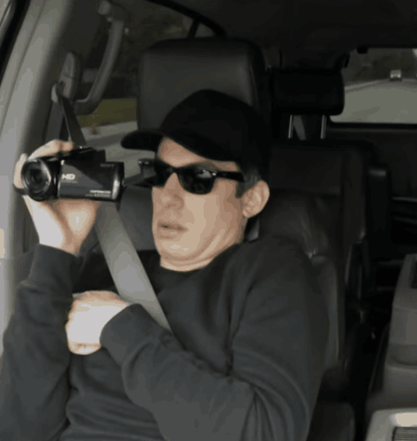 Man in Sunglasses and Hat Holding HD Camera