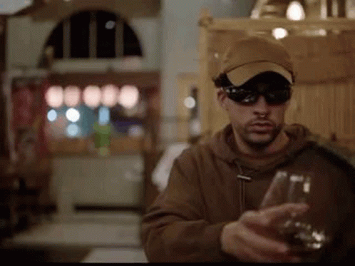Man in Sunglasses and Hat Holding Wine