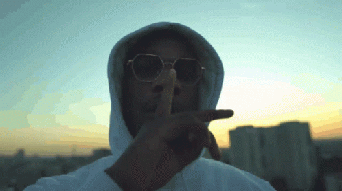 Man in Sunglasses and Hoodie Shushing