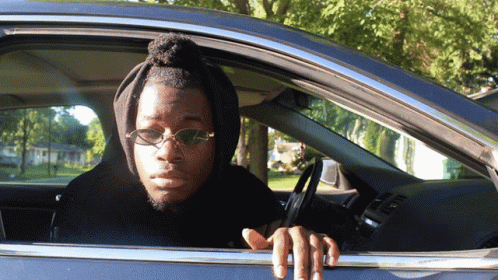 Man in Sunglasses and Hoodie Sitting in Car